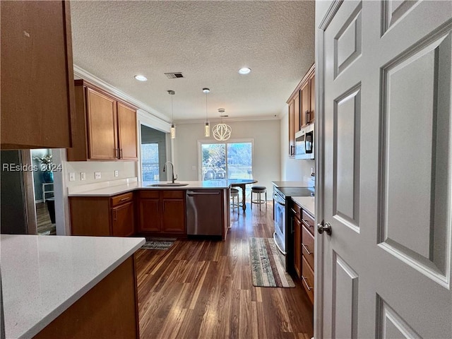 kitchen featuring crown molding, hanging light fixtures, stainless steel appliances, a textured ceiling, and kitchen peninsula