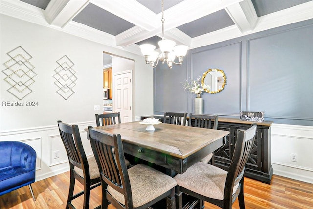 dining space with beamed ceiling, coffered ceiling, crown molding, an inviting chandelier, and light hardwood / wood-style flooring