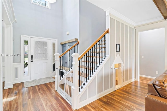 foyer featuring hardwood / wood-style flooring, ornamental molding, and beamed ceiling