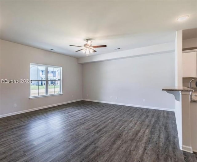 unfurnished living room featuring dark hardwood / wood-style floors and ceiling fan