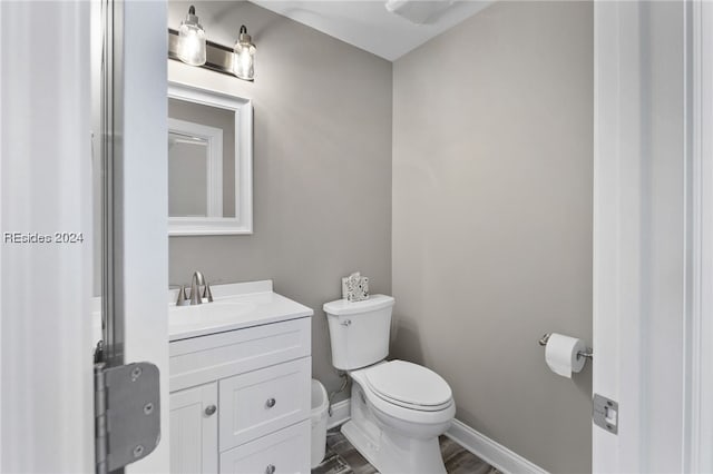 bathroom with vanity, hardwood / wood-style flooring, and toilet