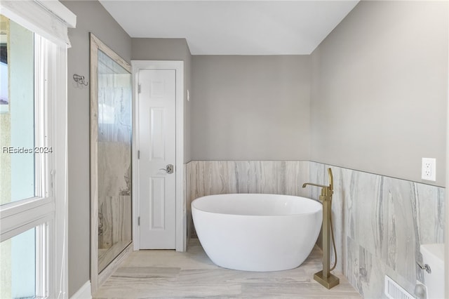 bathroom with tile walls and a tub