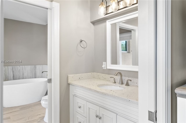 bathroom featuring toilet, tile walls, vanity, and a tub to relax in