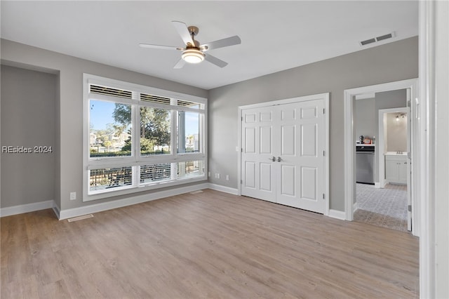 unfurnished bedroom featuring ceiling fan, light hardwood / wood-style floors, and a closet