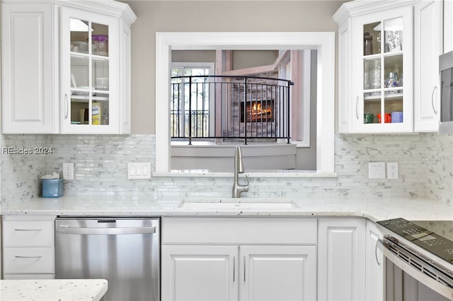 kitchen featuring white cabinetry, appliances with stainless steel finishes, sink, and backsplash