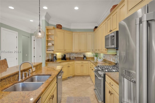 kitchen with light stone countertops, appliances with stainless steel finishes, sink, and decorative light fixtures