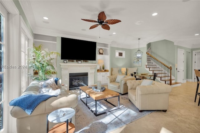 living room featuring crown molding, built in shelves, and ceiling fan