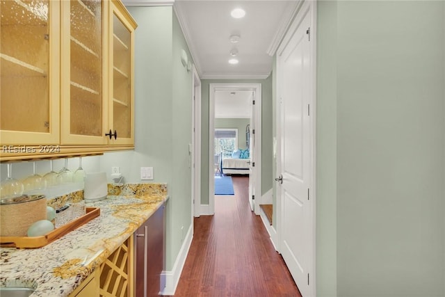 interior space featuring crown molding, dark hardwood / wood-style floors, light stone counters, and backsplash