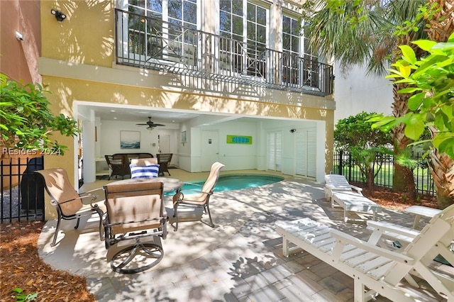 back of property with a fenced in pool, a patio, and ceiling fan