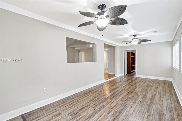 spare room featuring wood-type flooring, ornamental molding, and ceiling fan