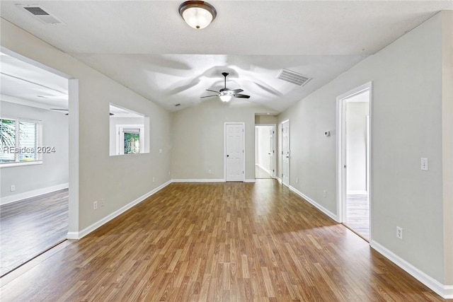 unfurnished room with lofted ceiling, hardwood / wood-style flooring, and ceiling fan