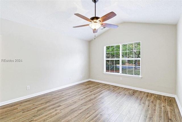 unfurnished room with light hardwood / wood-style flooring, a textured ceiling, vaulted ceiling, and ceiling fan