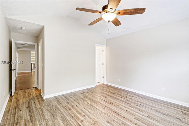 spare room with vaulted ceiling, ceiling fan, and light hardwood / wood-style flooring