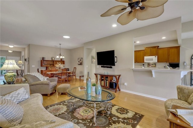 living room featuring light hardwood / wood-style flooring and ceiling fan