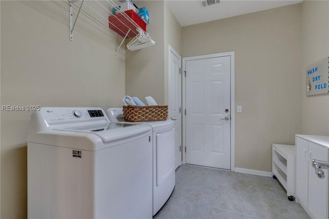 washroom featuring washer and dryer and light tile patterned floors