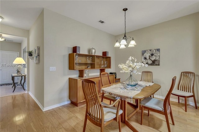 dining space featuring a chandelier and light wood-type flooring