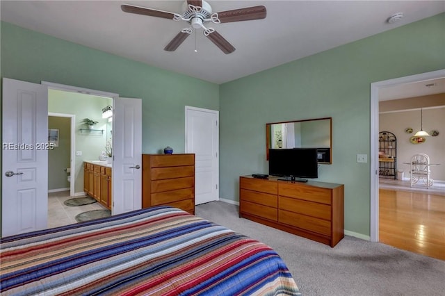 carpeted bedroom with connected bathroom and ceiling fan