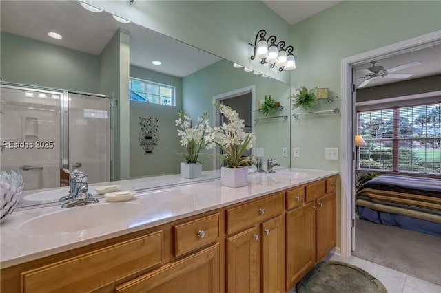 bathroom with vanity, ceiling fan, a shower with shower door, and a healthy amount of sunlight