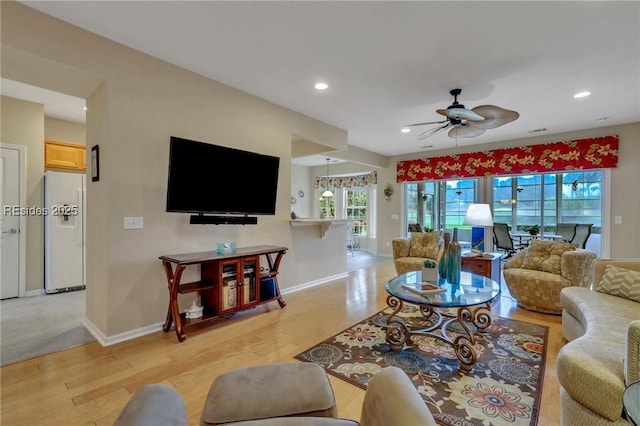 living room featuring ceiling fan and light hardwood / wood-style flooring