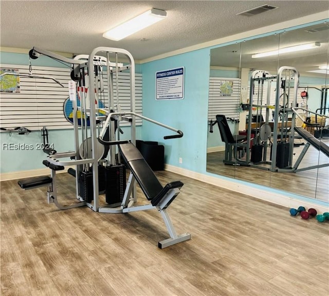 exercise room with wood-type flooring and a textured ceiling