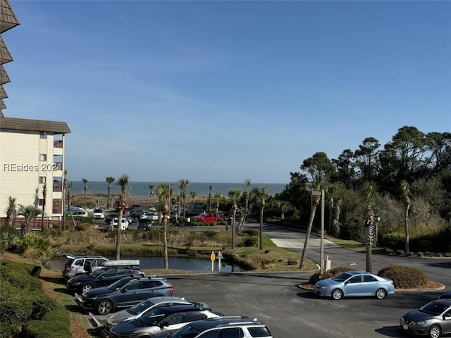 view of car parking featuring a water view