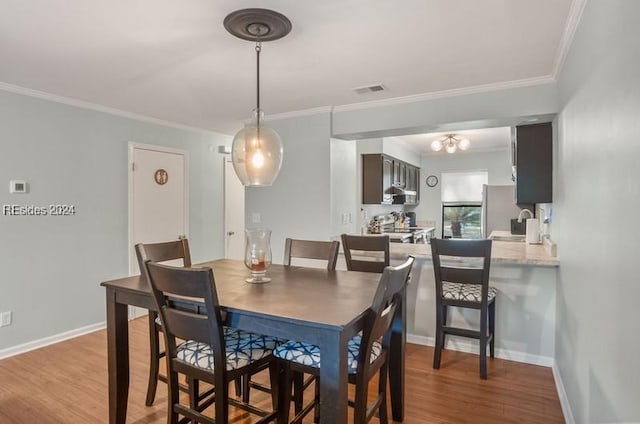 dining area featuring ornamental molding and light wood-type flooring