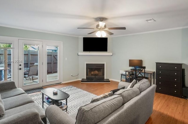 living room with ornamental molding, ceiling fan, light hardwood / wood-style floors, and french doors