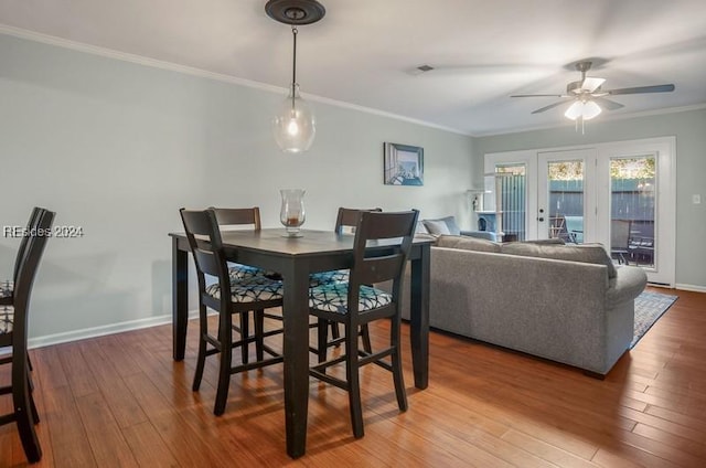 dining space with hardwood / wood-style floors, crown molding, and ceiling fan