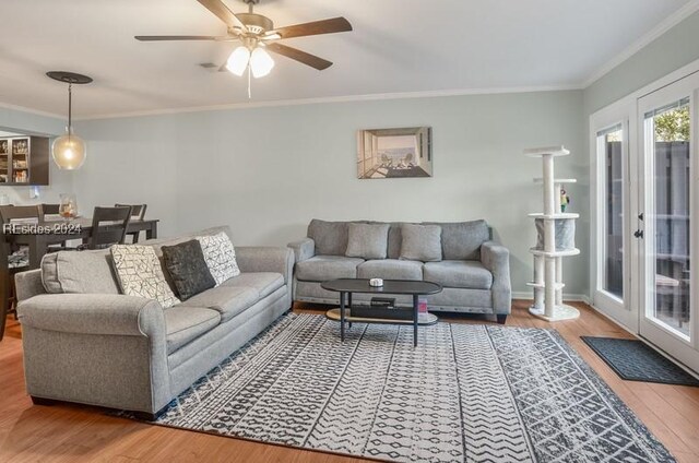 living room featuring crown molding, ceiling fan, and hardwood / wood-style floors