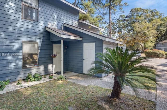 view of exterior entry featuring a yard