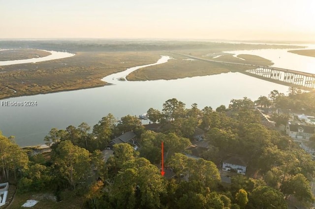 aerial view at dusk featuring a water view