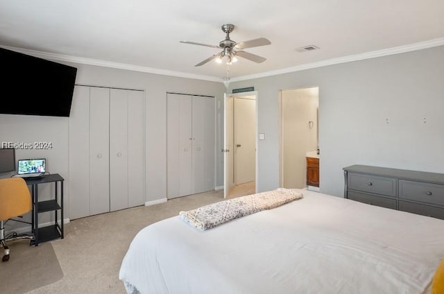 carpeted bedroom with connected bathroom, two closets, ornamental molding, and ceiling fan