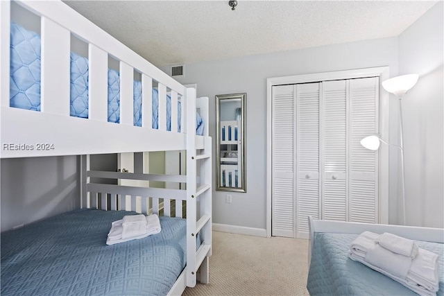 bedroom with carpet floors, a closet, and a textured ceiling