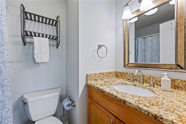 bathroom featuring vanity, a textured ceiling, and toilet