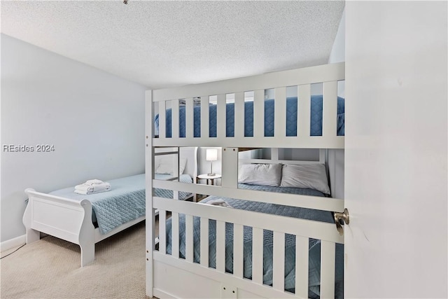 bedroom featuring light carpet and a textured ceiling