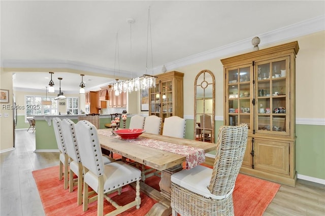 dining room featuring ornamental molding and light hardwood / wood-style flooring