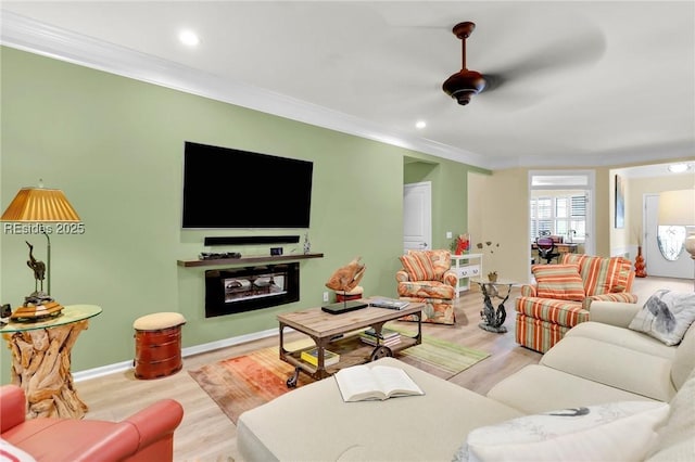 living room featuring ornamental molding, a fireplace, and light hardwood / wood-style floors