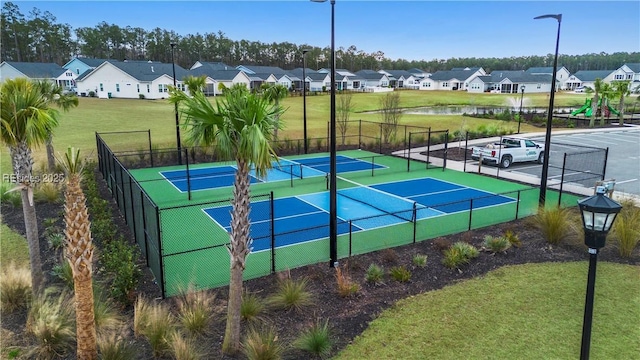 view of tennis court with a lawn