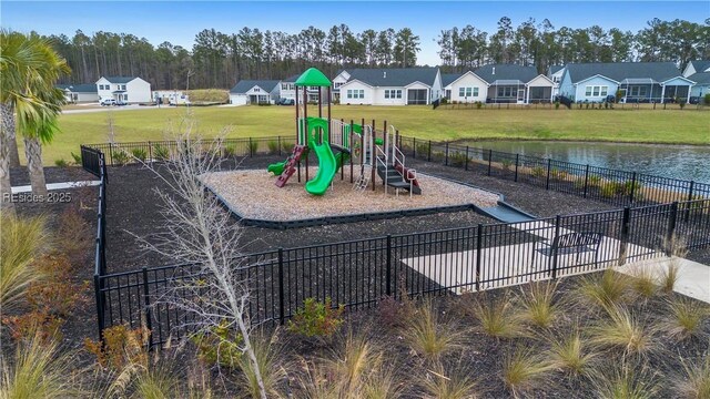 view of jungle gym featuring a water view and a yard