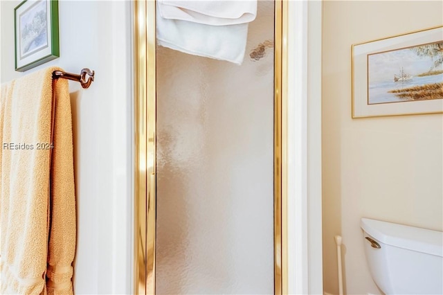 bathroom with toilet and an enclosed shower