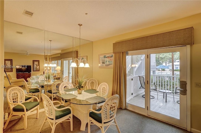 dining space with an inviting chandelier and carpet