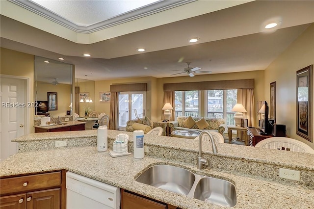 kitchen with sink, light stone counters, decorative light fixtures, white dishwasher, and ceiling fan