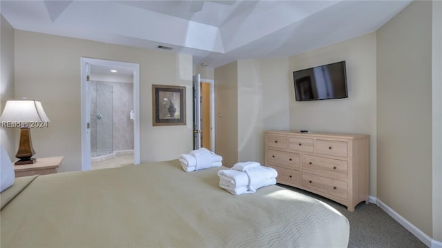 bedroom featuring ensuite bathroom, light colored carpet, and ceiling fan