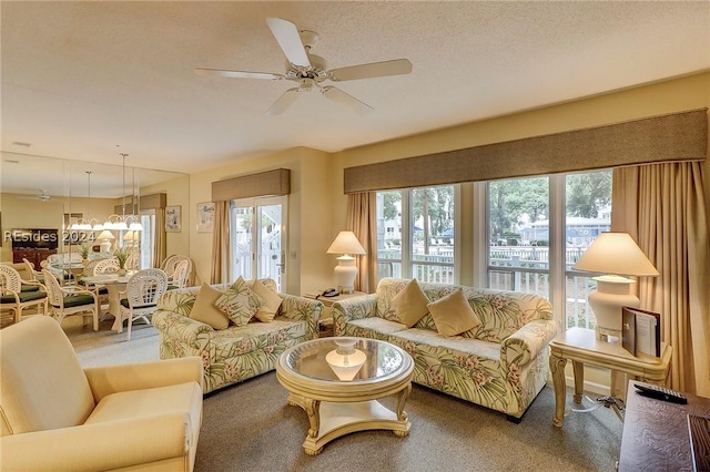 carpeted living room with a textured ceiling, a wealth of natural light, and ceiling fan