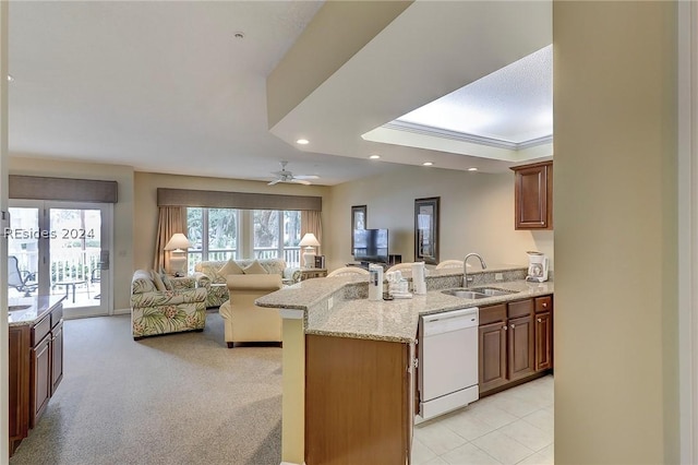 kitchen featuring sink, light stone counters, light carpet, white dishwasher, and ceiling fan