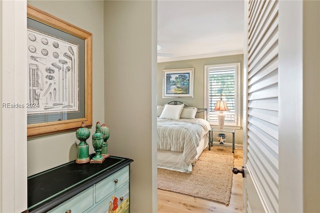 bedroom with ornamental molding and light wood-type flooring