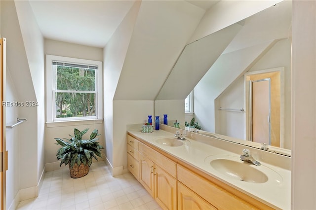 bathroom with lofted ceiling, vanity, and a wealth of natural light