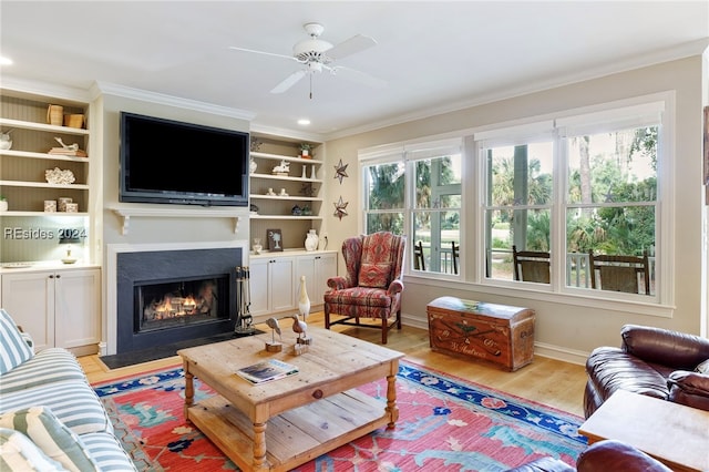 living room featuring ornamental molding, ceiling fan, and light wood-type flooring