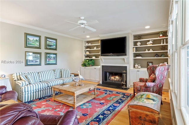 living room featuring built in shelves, ornamental molding, and hardwood / wood-style floors