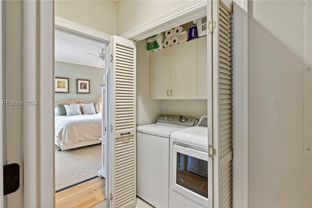 washroom featuring crown molding, light hardwood / wood-style flooring, ceiling fan, washing machine and dryer, and cabinets